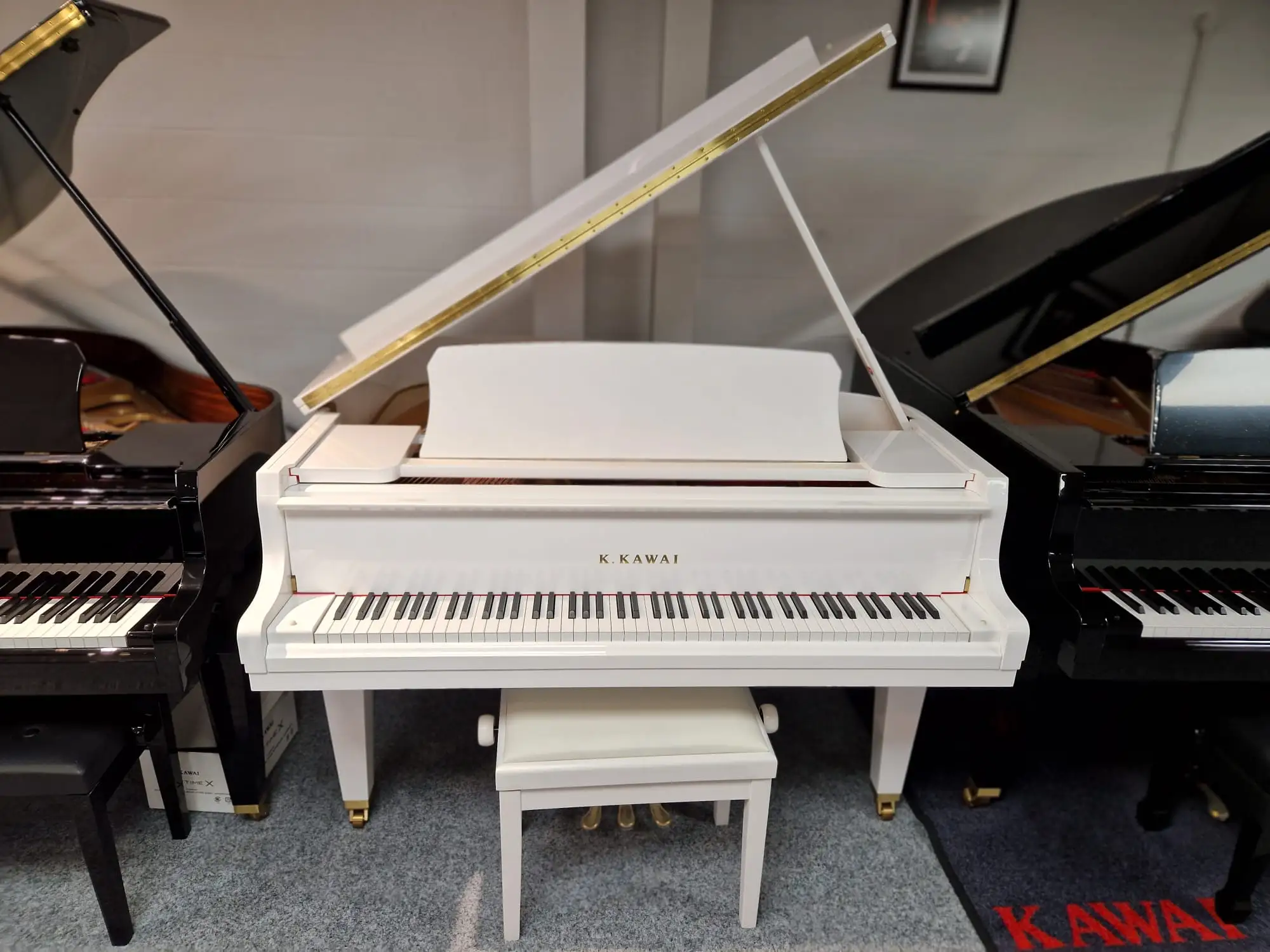 A white Kawai upright piano in a showroom